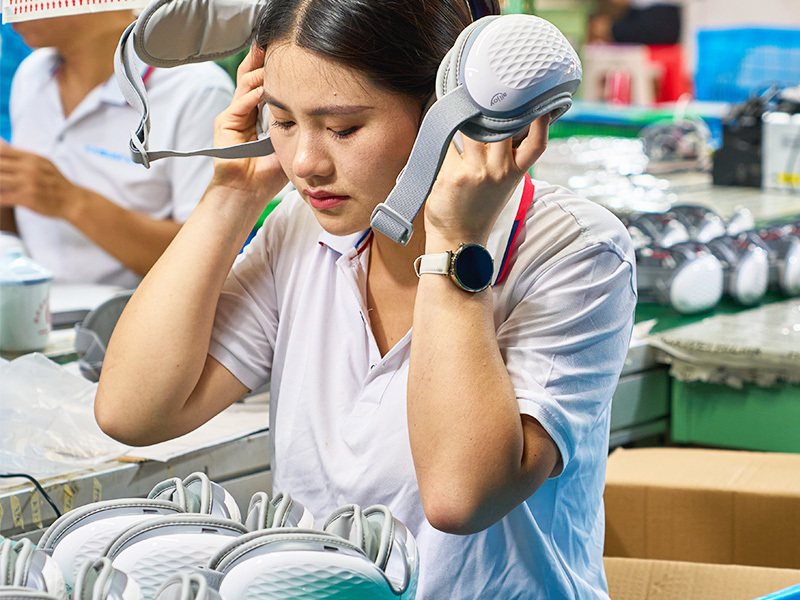 A Kaisum technician testing a head massager on the line