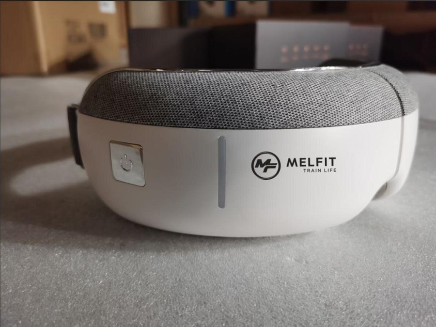 Kaisum eye massager built for Melfit, grey mesh over a white housing with the Melfit logo